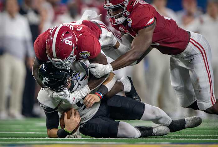 Cincinnati Bearcats quarterback Desmond Ridder (9) is sacked by Alabama Crimson Tide linebacker Christian Harris (8) during the third quarter during the 2021 Cotton Bowl college football CFP national semifinal game at AT&T Stadium.